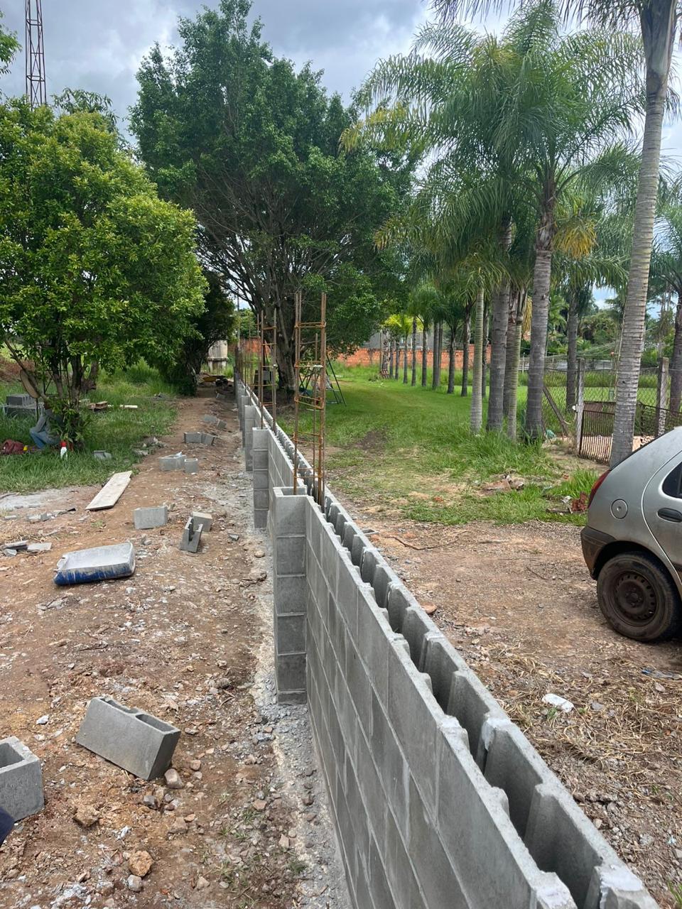 Bloco estrutural Vinic em aplicação — muro residencial em construção com ferragens à mostra